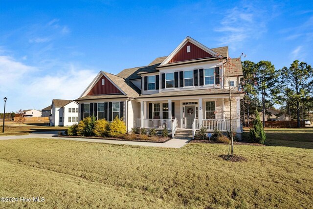 craftsman house with a porch, a front lawn, and board and batten siding