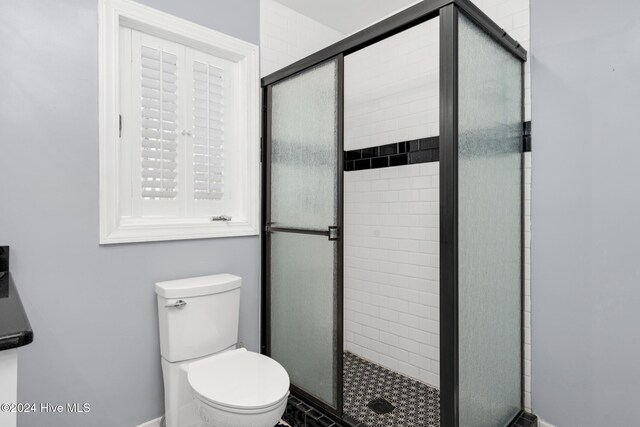 bathroom featuring an enclosed shower and toilet