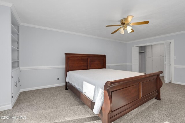 carpeted bedroom featuring ceiling fan, crown molding, and a closet