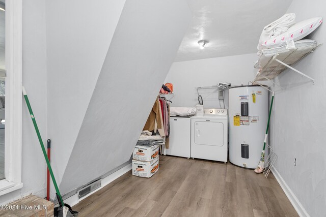 laundry area featuring washer and clothes dryer, light wood-type flooring, and water heater