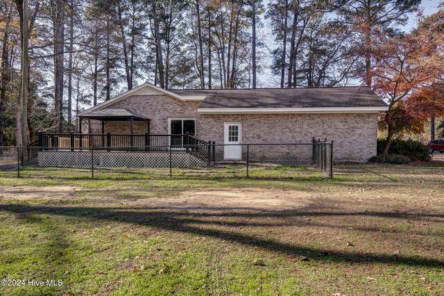 rear view of property featuring a yard and a deck