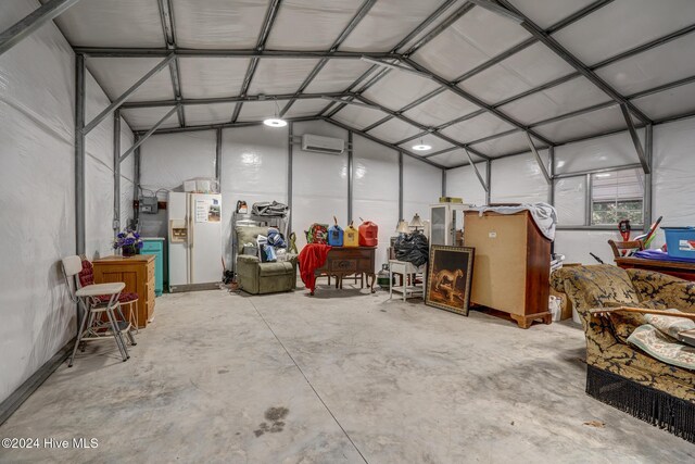 garage with white refrigerator with ice dispenser and an AC wall unit