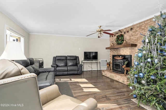 living room featuring ceiling fan, dark hardwood / wood-style flooring, a wood stove, and crown molding