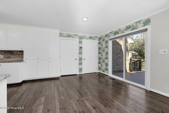 interior space with dark hardwood / wood-style flooring and ornamental molding