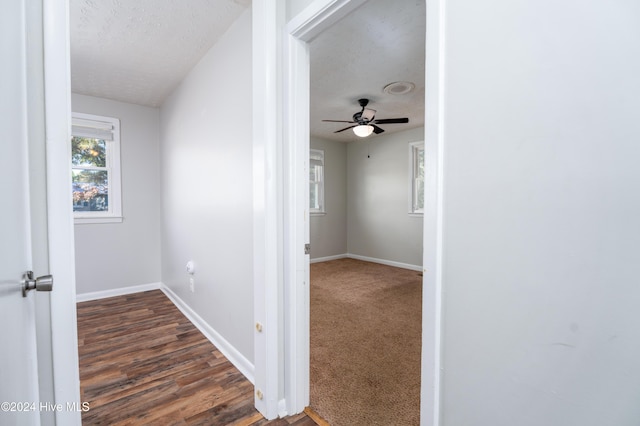 hall with dark wood-type flooring and a textured ceiling