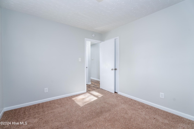 empty room featuring carpet flooring and a textured ceiling