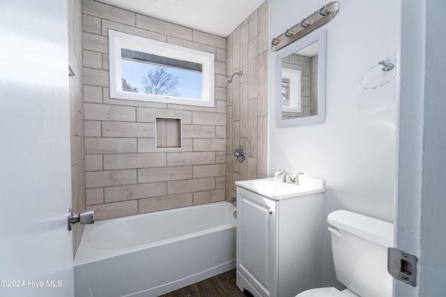 full bathroom with hardwood / wood-style flooring, toilet, vanity, and tiled shower / bath