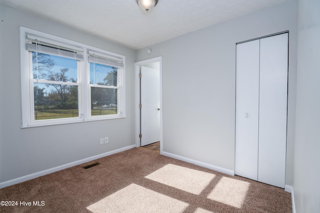 unfurnished bedroom with a closet and carpet floors