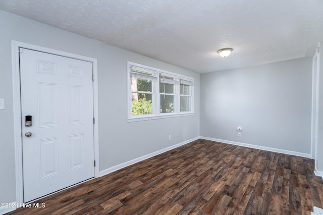 foyer entrance featuring a textured ceiling and dark hardwood / wood-style floors