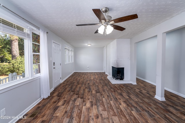 unfurnished living room featuring dark hardwood / wood-style floors, plenty of natural light, and a fireplace