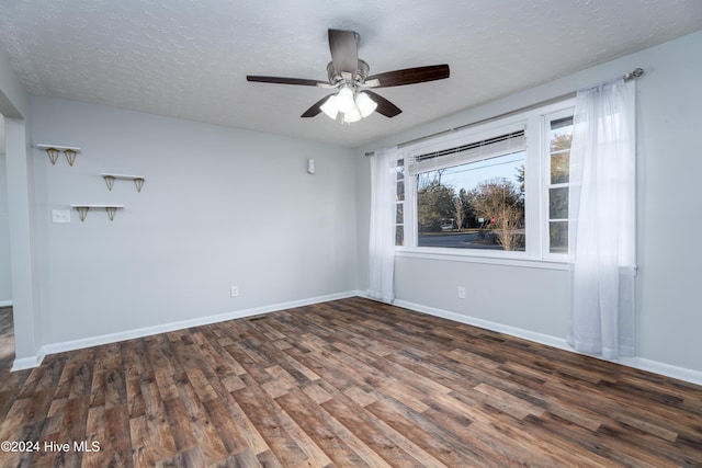 empty room with a textured ceiling, dark hardwood / wood-style floors, and ceiling fan