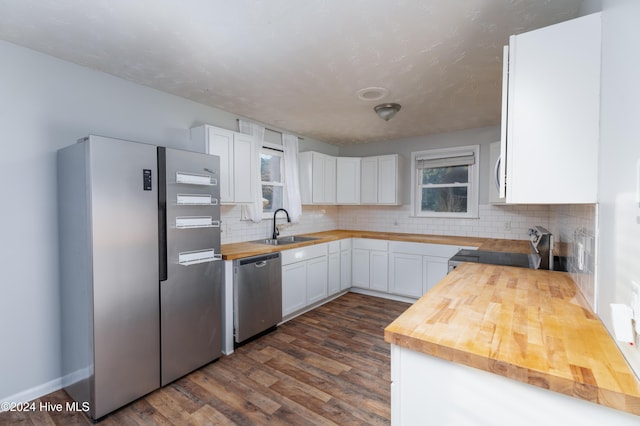 kitchen featuring white cabinetry, sink, dark hardwood / wood-style floors, butcher block countertops, and appliances with stainless steel finishes