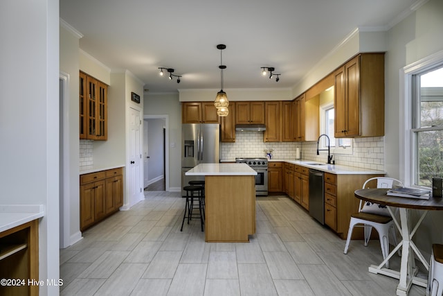 kitchen featuring pendant lighting, a breakfast bar, sink, a kitchen island, and stainless steel appliances