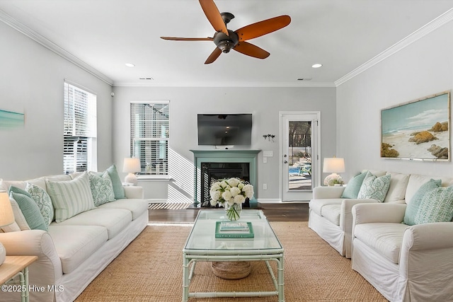 living room with hardwood / wood-style floors, crown molding, and ceiling fan