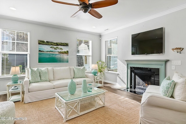 living room with hardwood / wood-style flooring, ceiling fan, and ornamental molding