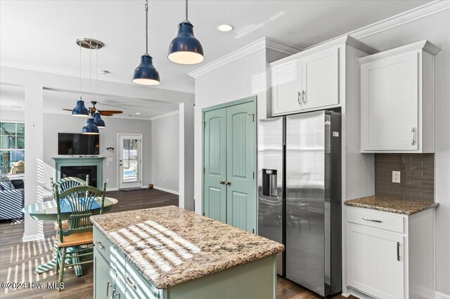 kitchen featuring a kitchen island, pendant lighting, white cabinetry, stainless steel fridge, and backsplash