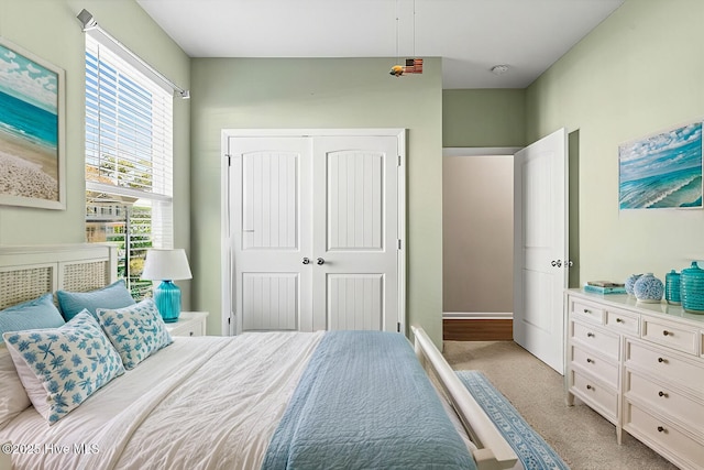 bedroom with light carpet and a closet