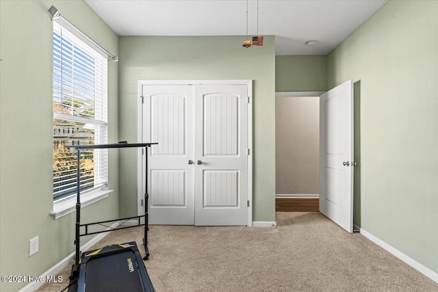 exercise room featuring light carpet