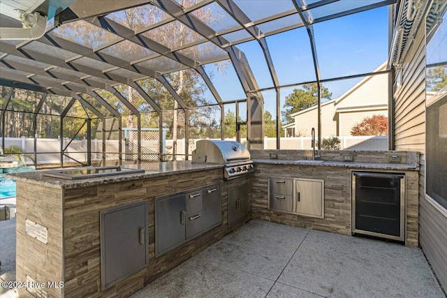 view of patio / terrace with an outdoor kitchen, a grill, beverage cooler, and sink