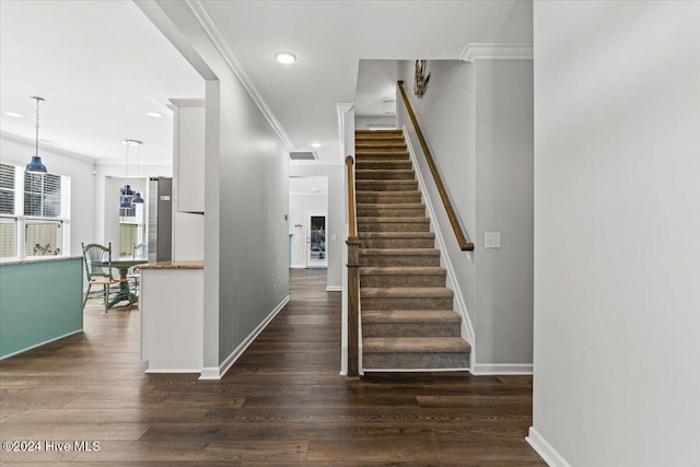 stairs featuring hardwood / wood-style floors and crown molding