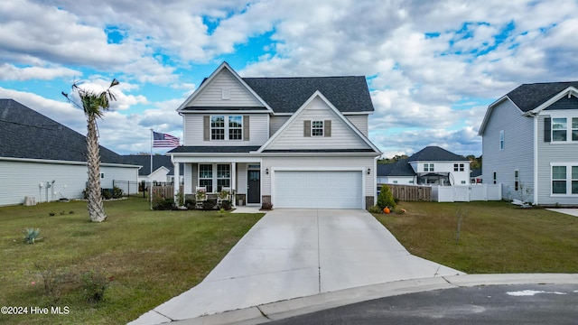 view of front of house featuring a front yard, a garage, and covered porch