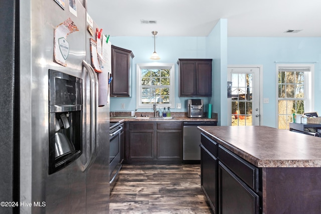 kitchen with pendant lighting, sink, dark hardwood / wood-style floors, a kitchen island, and stainless steel appliances