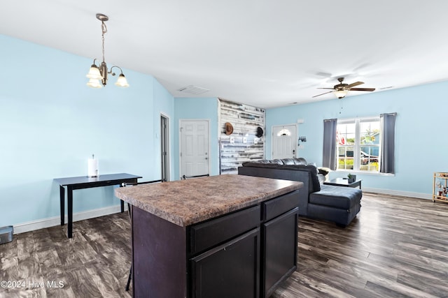 kitchen featuring ceiling fan with notable chandelier, dark hardwood / wood-style flooring, a kitchen island, and hanging light fixtures