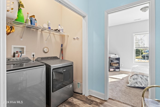 clothes washing area featuring hardwood / wood-style floors and washing machine and dryer