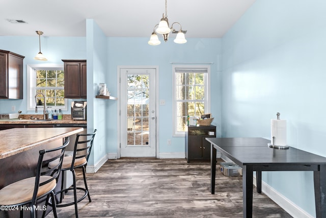 kitchen featuring hanging light fixtures, dark brown cabinets, a chandelier, and dark hardwood / wood-style floors