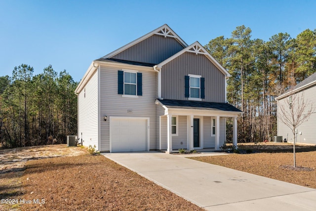 view of front of house featuring covered porch, a garage, and central AC unit