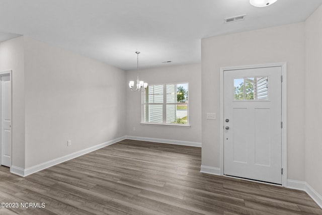 foyer with a chandelier and wood-type flooring