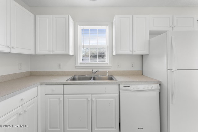 kitchen featuring sink, white cabinets, and white appliances