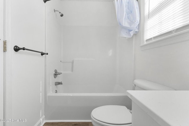 bathroom with tub / shower combination, hardwood / wood-style floors, and toilet