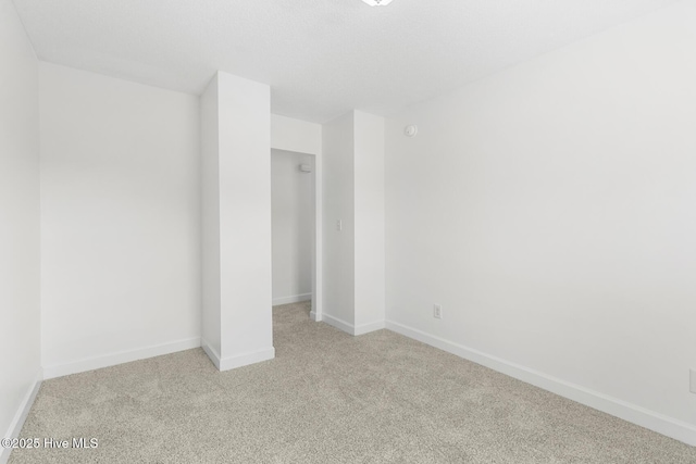 unfurnished room featuring light carpet