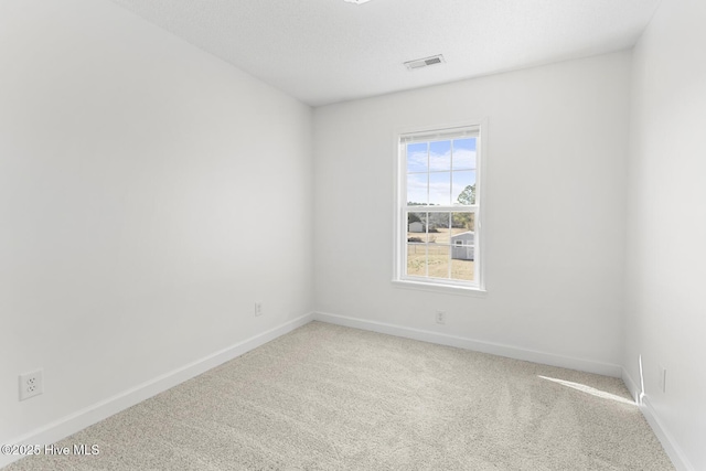 unfurnished room featuring carpet flooring and a textured ceiling