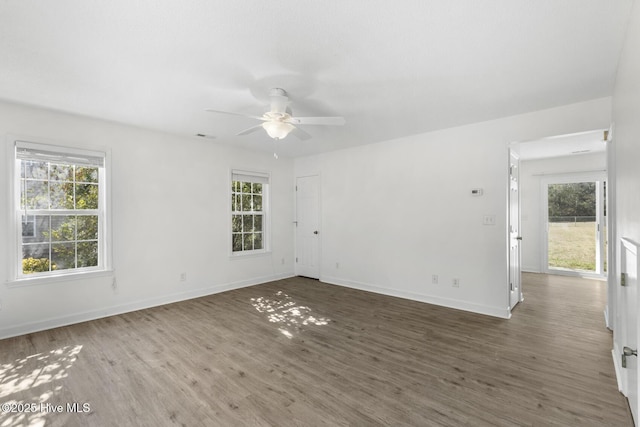 unfurnished room with dark hardwood / wood-style flooring, ceiling fan, and a healthy amount of sunlight