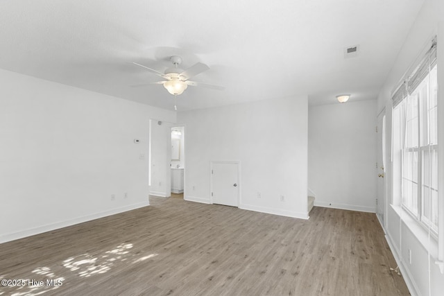 empty room with ceiling fan and light hardwood / wood-style floors