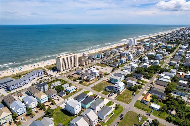 birds eye view of property with a water view and a beach view