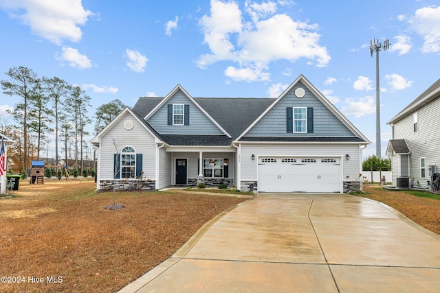 craftsman-style home with a front yard, central AC unit, and a garage