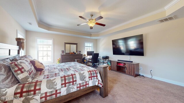 bedroom with a tray ceiling, visible vents, light carpet, and ornamental molding