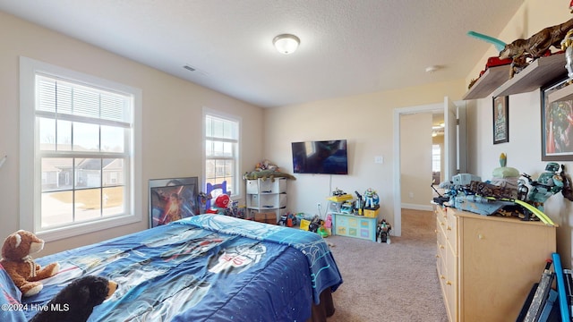 bedroom with baseboards, visible vents, a textured ceiling, and carpet