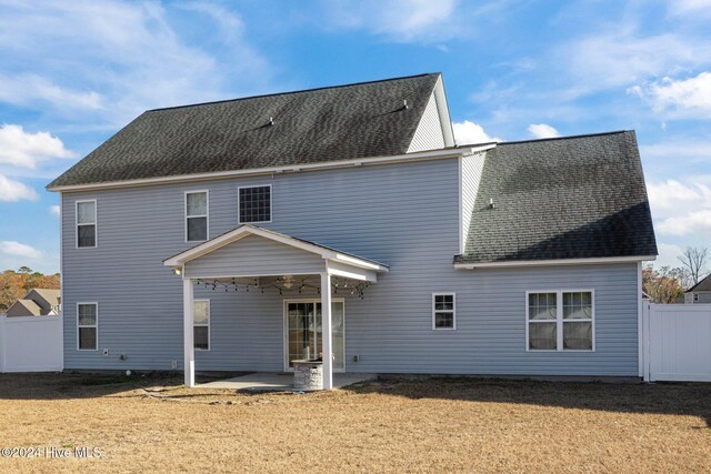 rear view of house featuring a yard and a fire pit