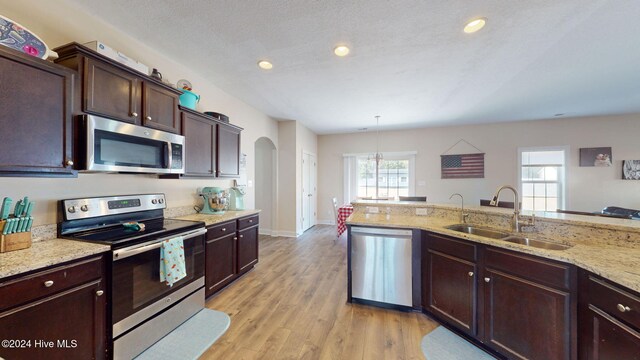 living room featuring baseboards, light wood-style flooring, and stairs