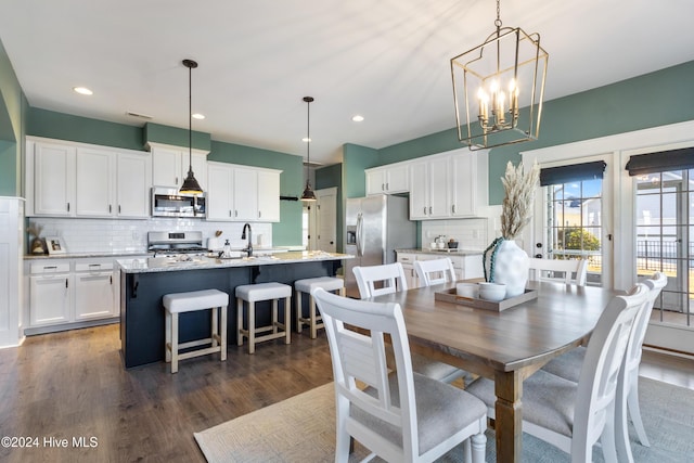 dining room with dark hardwood / wood-style flooring, a notable chandelier, and sink