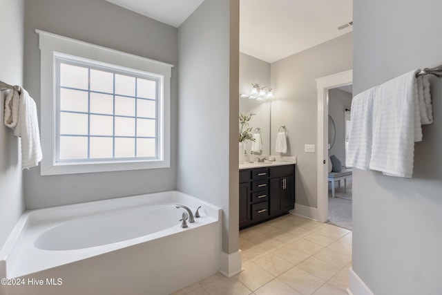 bathroom featuring tile patterned floors, vanity, and a tub to relax in