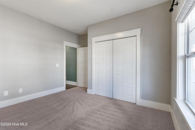 unfurnished bedroom with carpet floors and a closet