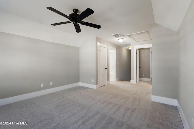 carpeted spare room featuring ceiling fan and vaulted ceiling