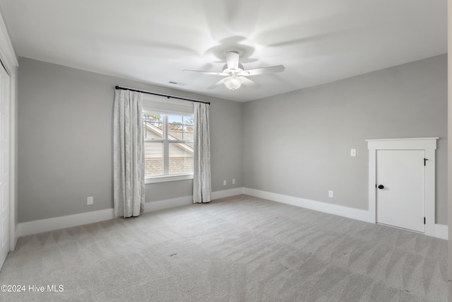 carpeted spare room with ceiling fan