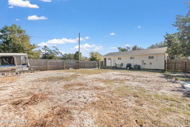 view of yard with central air condition unit and a fenced backyard