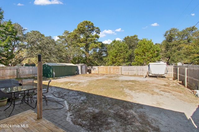 view of yard featuring a storage shed, outdoor dining area, and a fenced backyard